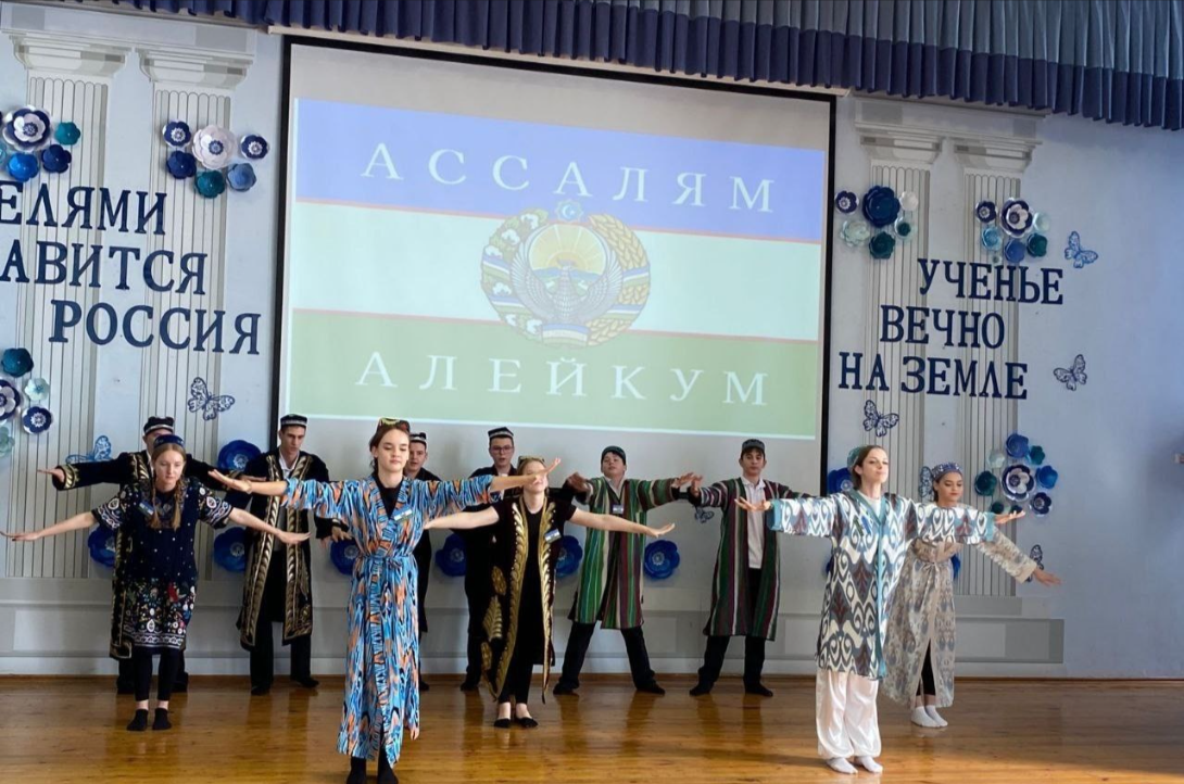 В Краснодаре местных детей нарядили в узбеков, запилили во всю стену изображение узбекского флага и заставили исполнять кишлачные танцы